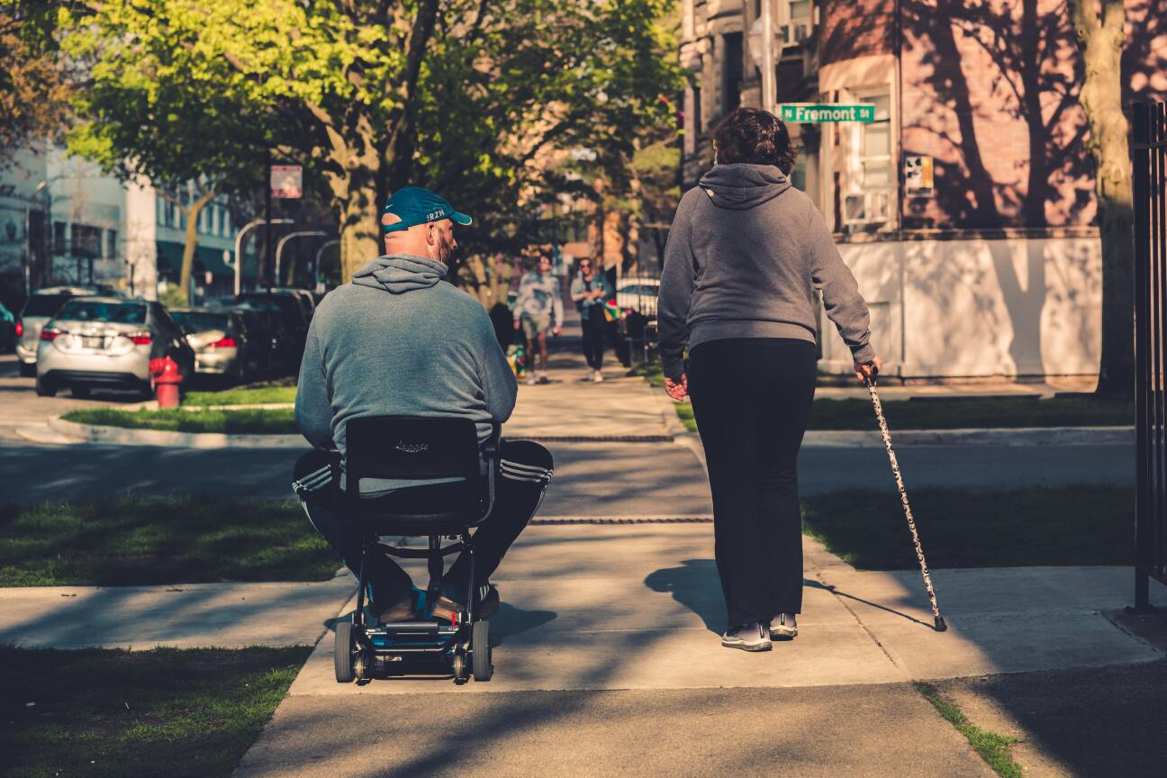 Bild © Bild: Unsplash Mann im Rollstuhl und Frau mit Gehstock, Bild © Bild: Unsplash