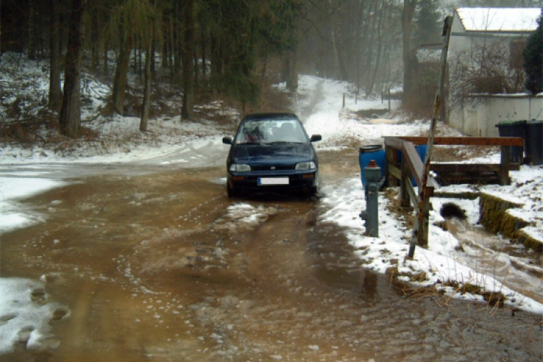Im Winter läuft ein kleiner Bach im Holzheimer Graben über.