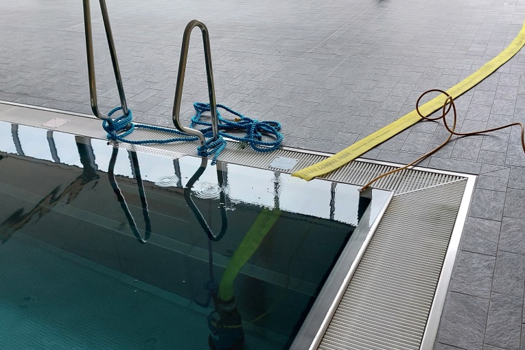 Mit einer Pumpe wird Schwimmbadwasser aus dem Becken gepumpt