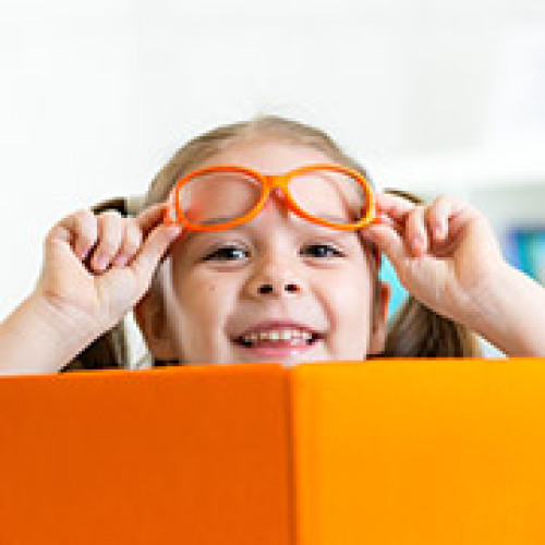 Kind lacht mit orangefarbenen Buch © Oksana Kuzmina / stock.adobe.com