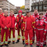 Gruppenfoto mit acht Mitgliedern der DLRG in roter Kleidung auf der Liebesinsel.